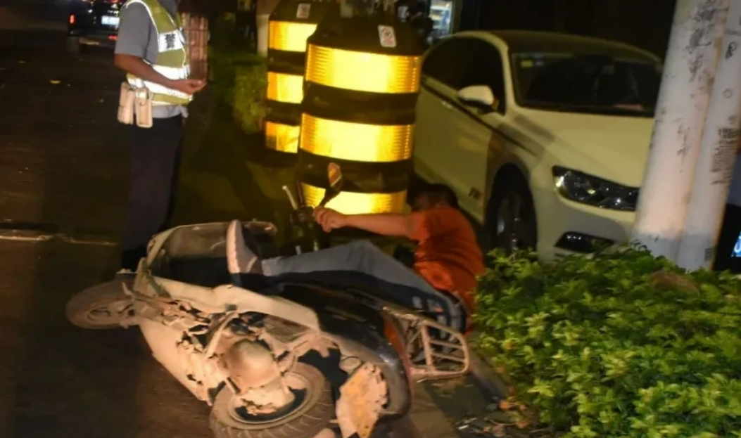 广东中山，一男子将摩托车扔在一旁，径直躺在路边睡觉，路人发现后随即报了警，交警来