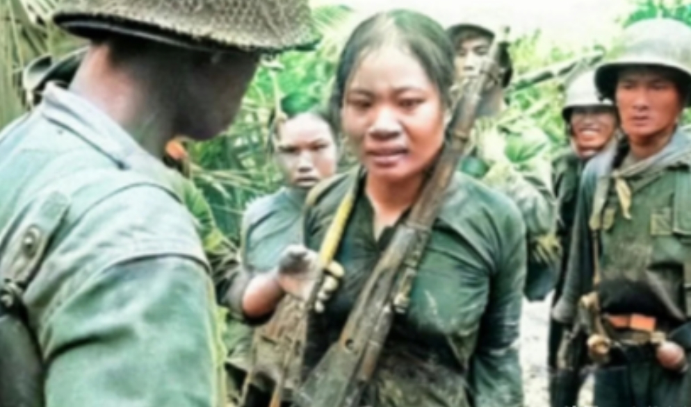 1965年，几名韩国士兵抓住两位越南女兵后，把枪退掉子弹，重新再挂在女兵的脖子上