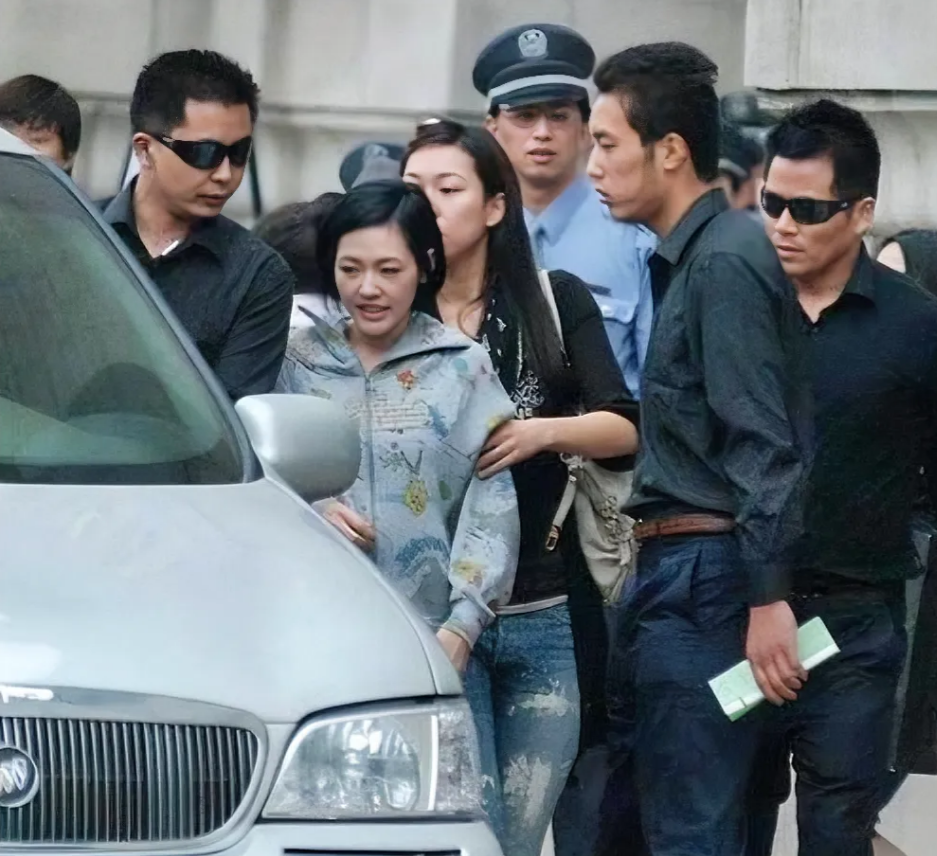 好大的阵仗，一出门就前呼后拥，保安开道、保镖守护，看来这位女士的身份不简单呀。仔