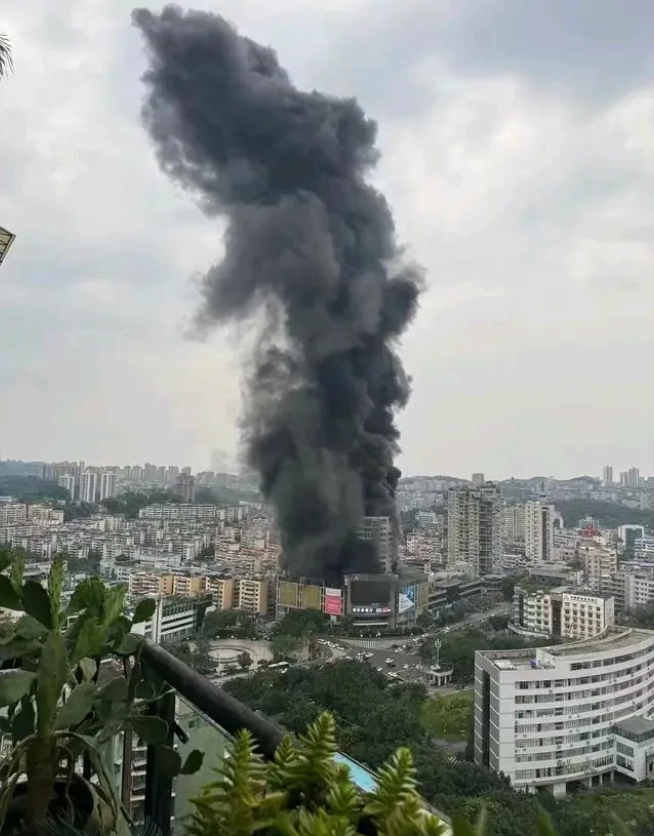 从不同角度观察四川自贡九鼎百货大楼的火灾现场。
从远处望去，只见浓烟滚滚，熊熊烈