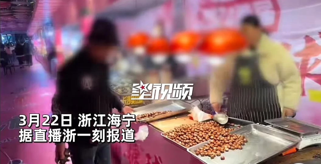 浙江海宁，一男子在美食街买了2斤糖炒栗子，随后，男子拿着自带的电子秤准备称一下看