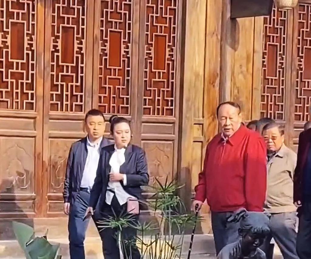 80高龄的梁光烈上将回到家乡四川三台祭祖，此时的他穿着红色的便装外套，并参观了潼