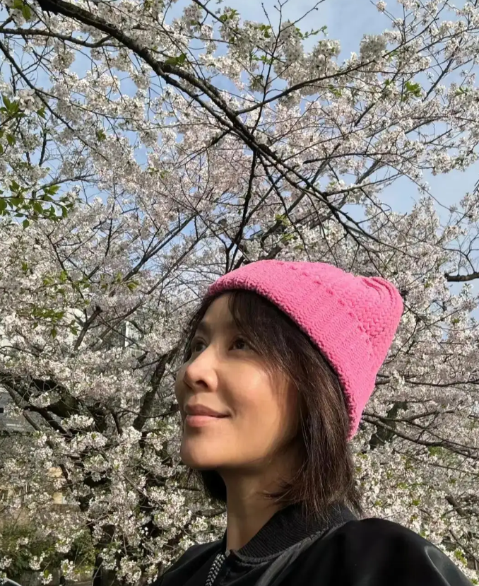 刘嘉玲在日本，58岁的她笑容恬淡的站在樱花树下，无惧年龄素颜出镜，状态非常好。