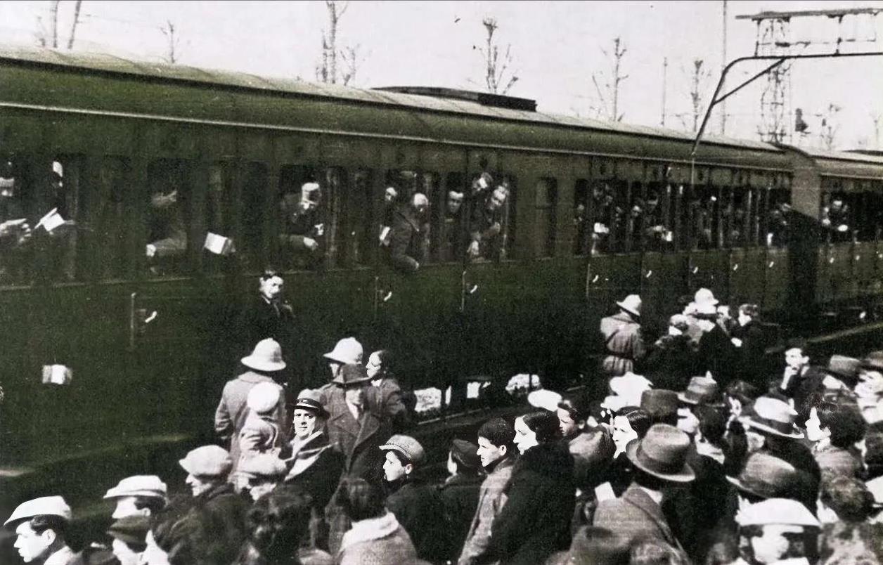 1936年3月16日，志愿加入军队的意大利士兵正在火车上与送行的亲人们告别，他们