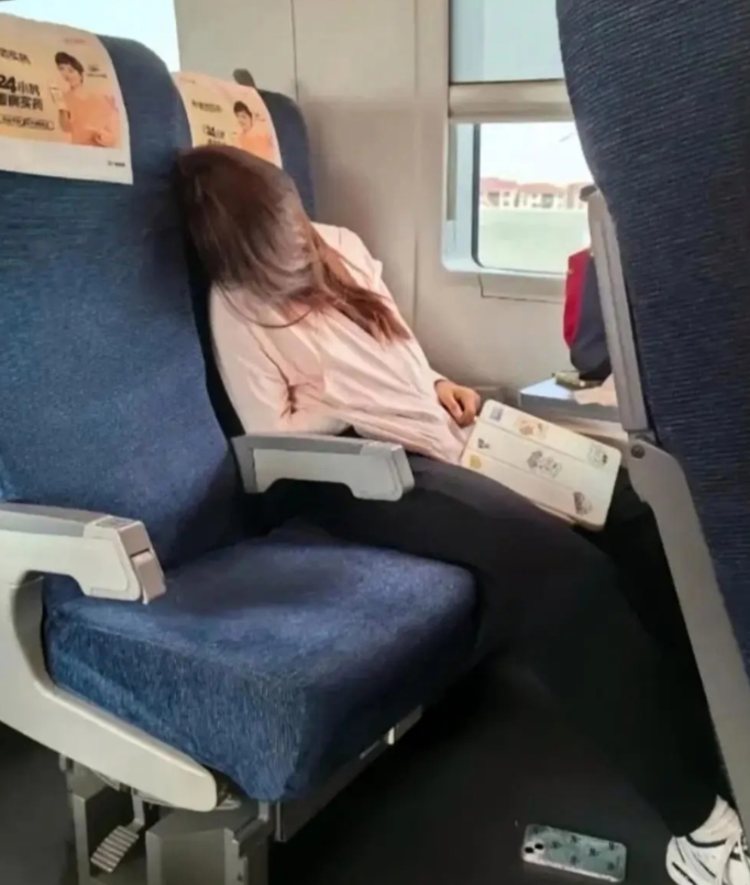 在火车上，坐在我旁边的这位美女竟然睡着了，手机也掉在了地上，关键是现在火车已经到