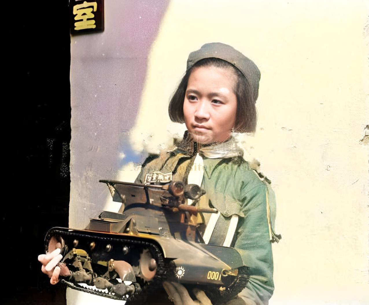 1942年，抗战大后方抗日军人子女学校的一名女学生抱着一辆坦克模型。这辆坦克模型