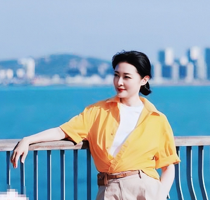 岁月从不败美人，56岁的周涛在青岛游玩时的照片。镜头下的她身穿白色打底衫，外配亮