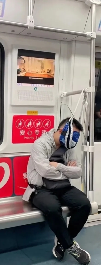 这个哥们是咋回事，这是怕睡着了自己栽地下吗？还是在做颈椎牵引？在地铁里这样做很吸