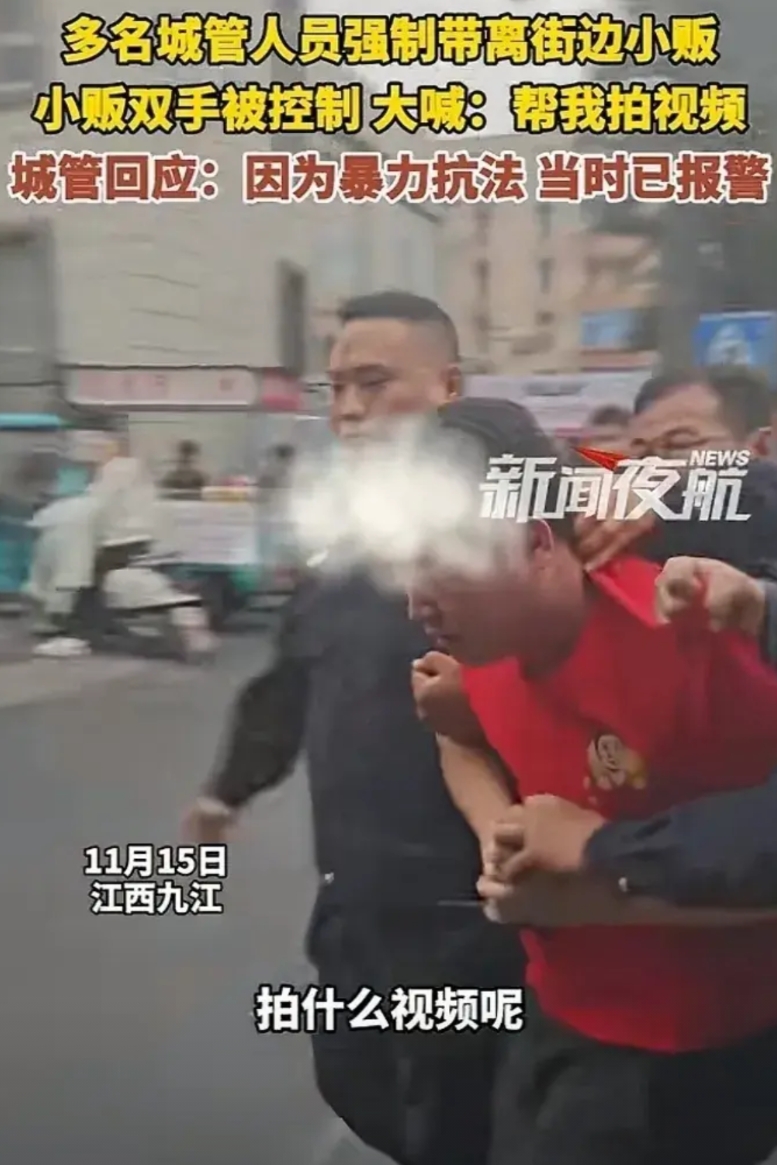 江西九江，一摊贩被多名执法人员控制住双手架走，他一边反抗，一边对着周围群众大喊，
