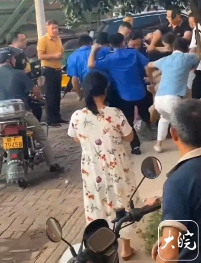 一名男子遭到多名城管的拳打脚踢，女子奋不顾身地护着他，女子那刺痛人心的哭声引来了
