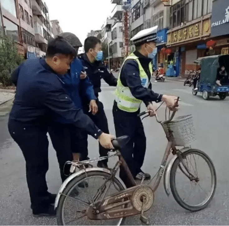 这张照片拍摄于2023年，上海退休法学教授李自忠骑自行车接孙女上放学时，被交警以