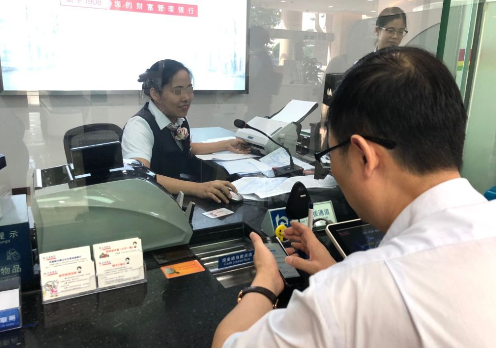 上海，一男子拿着10万现金到银行存钱，银行窗口的职员接过钱后，按照程序将10万现