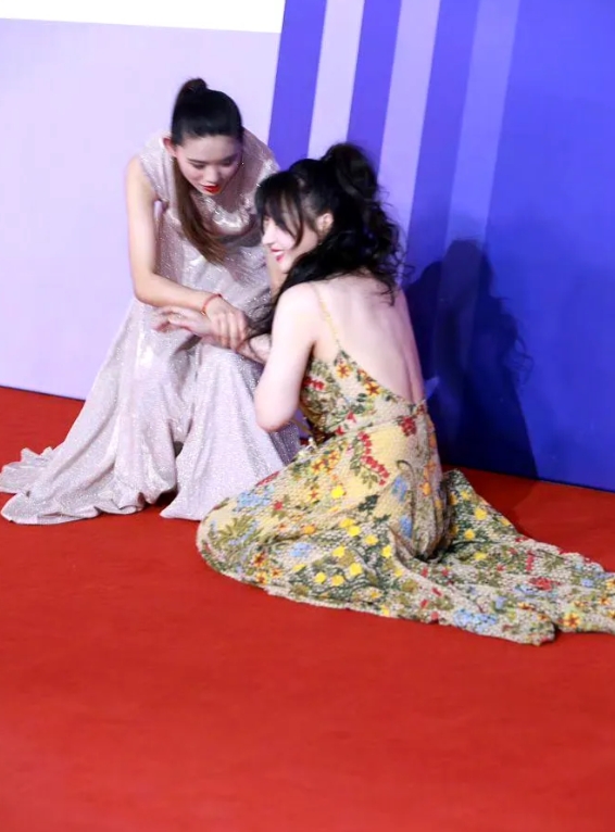柳岩之前还在红毯上摔倒过，摔得还挺疼，两个工作人员帮她扶起来，她即使再疼也含笑忍