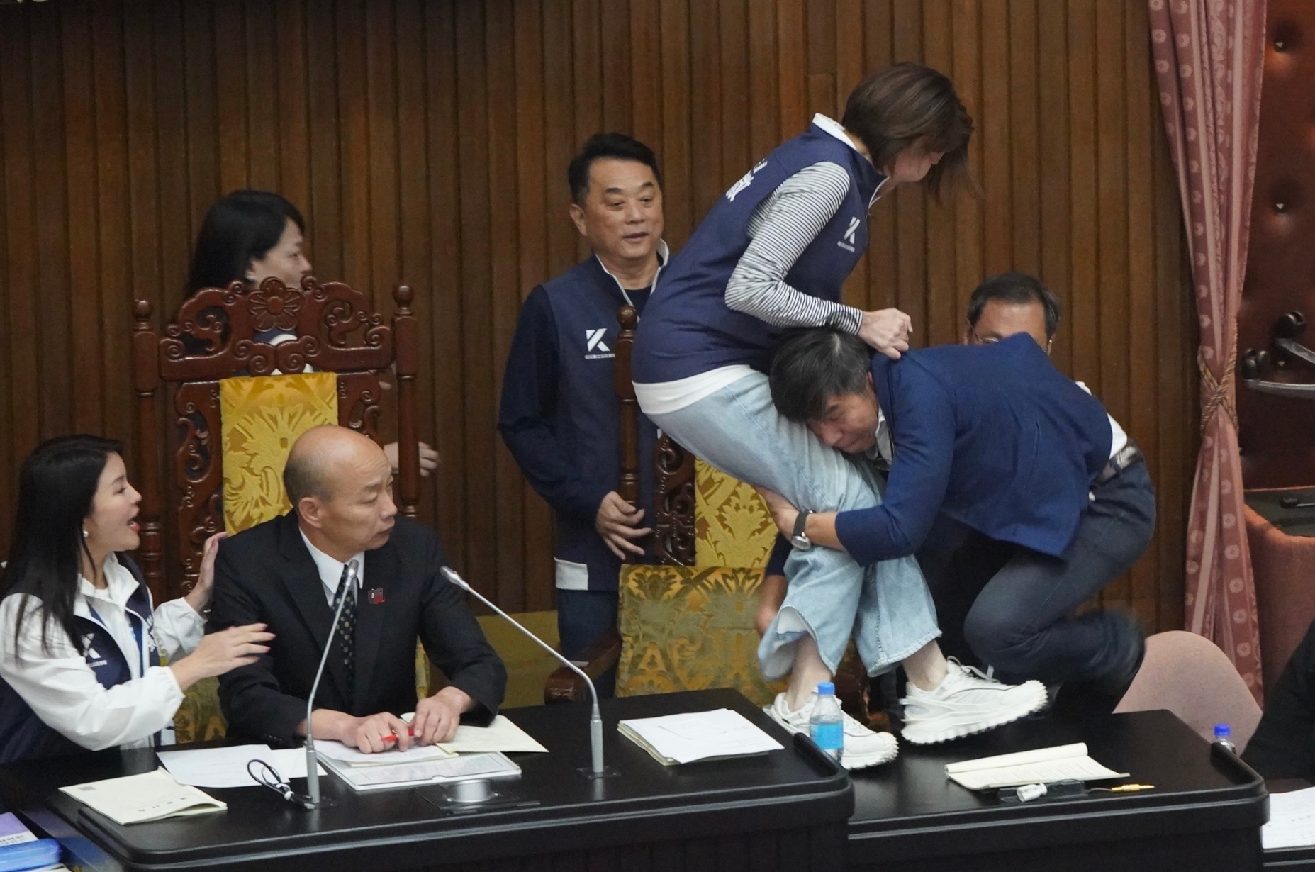 民进党的锺佳滨冲向主席台，直接把站在主席台上的国民党陈菁徽抱摔到地上。