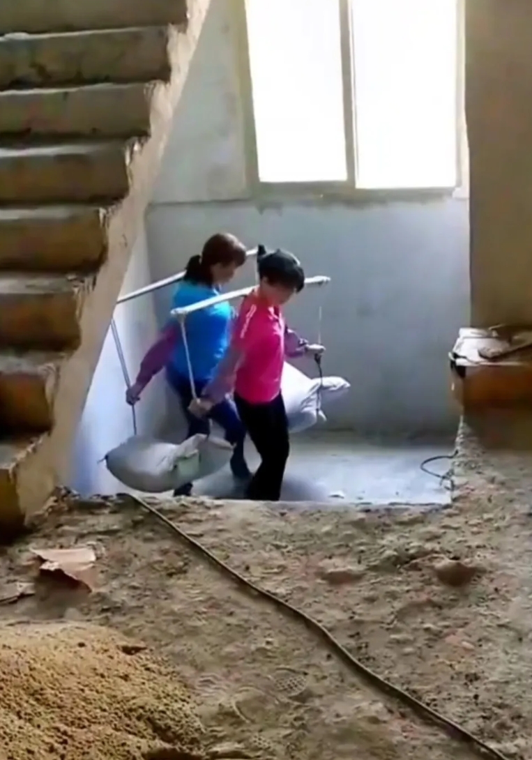 高手在民间呀，不得不服，这两女子配合默契，两包水泥200斤轻轻松松就抬上来了，真