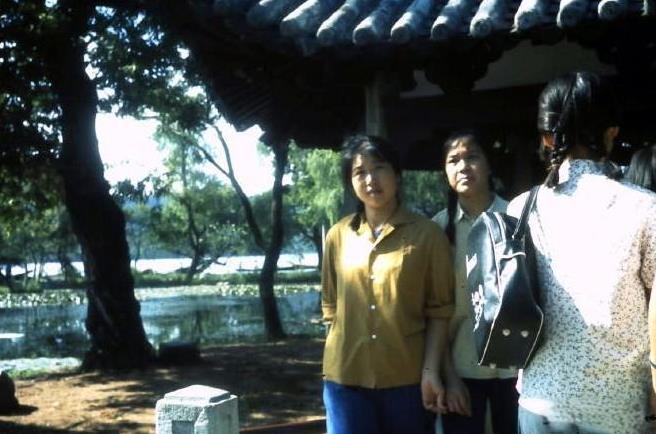 1974年，两名年轻姑娘手牵手游览颐和园。她们梳着两条长辫子，并未描眉搽粉，有一