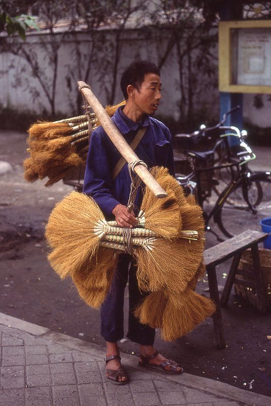 八十年代成都街头一小贩挑着扫帚沿街叫卖