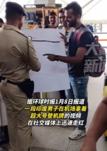 一印度男子在机场上拿出超大登机牌，并一脸自信的拿给一旁的警察检查。

警察原本想