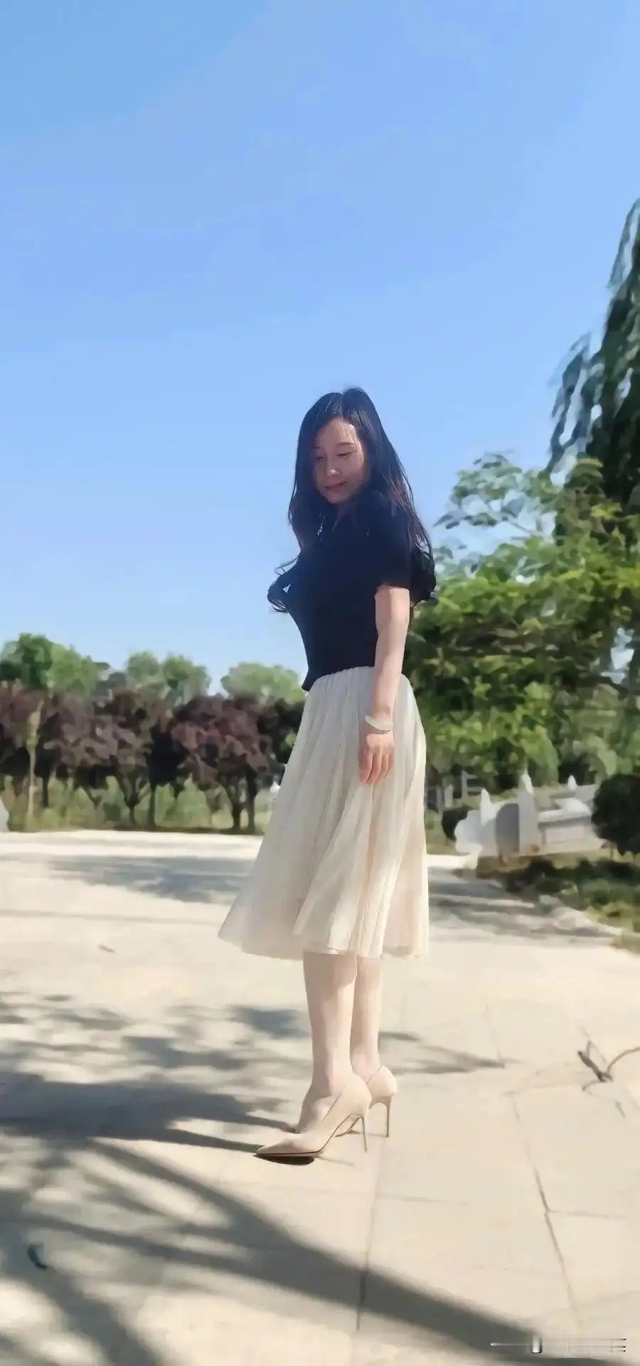 黑上衣配白纱裙，高跟添优雅，漫步阳光下。