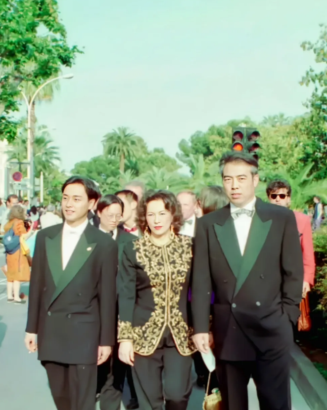 左边英俊潇洒、相貌出众的男子，是香港影、视、歌三栖巨星张国荣。他唱功深厚，嗓音独