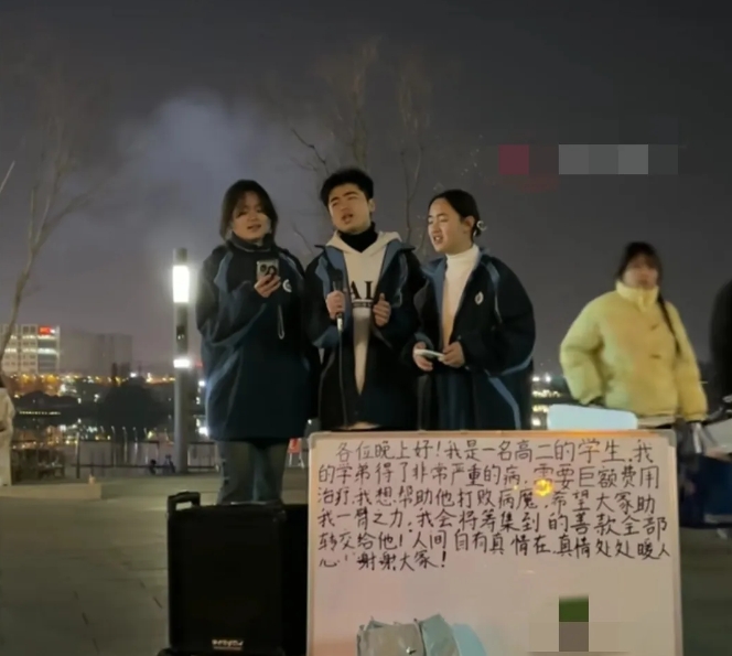 寒冷的街头，几名穿着校服的学生，轮流向路人献唱，看见地上放着的牌子，让人瞬间就感