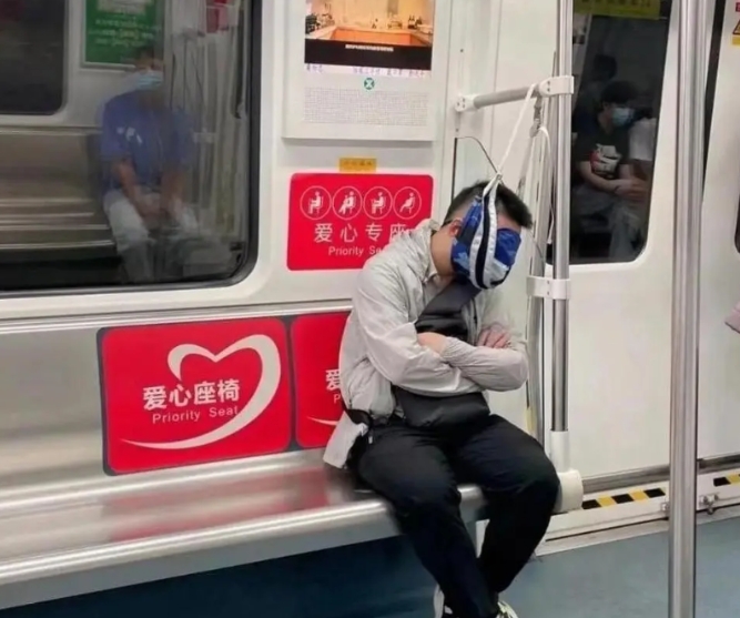 这哥们儿，真是地铁里的奇葩一朵！他把自己的包挂在了扶手上，然后脖子放上去，整个人