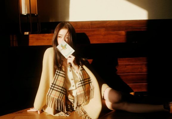 任敏披着卡其色斗篷，那衣裳的轮廓因张力线条而生动，仿佛是都市的剪影，在她身上勾勒