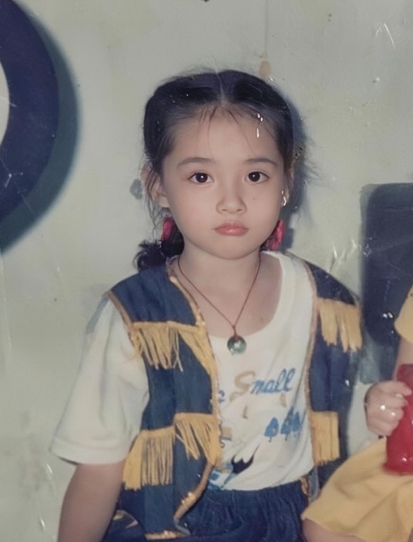 郭碧婷童年照，果真是从小美到大。镜头下的她身穿白色的短袖搭配蓝色的背心，眼睛炯炯