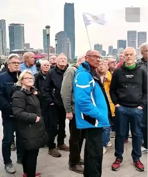 这张照片让人深思，上海外滩，一群老外来中国旅游，他们的表情凝重，根本就看不到旅游