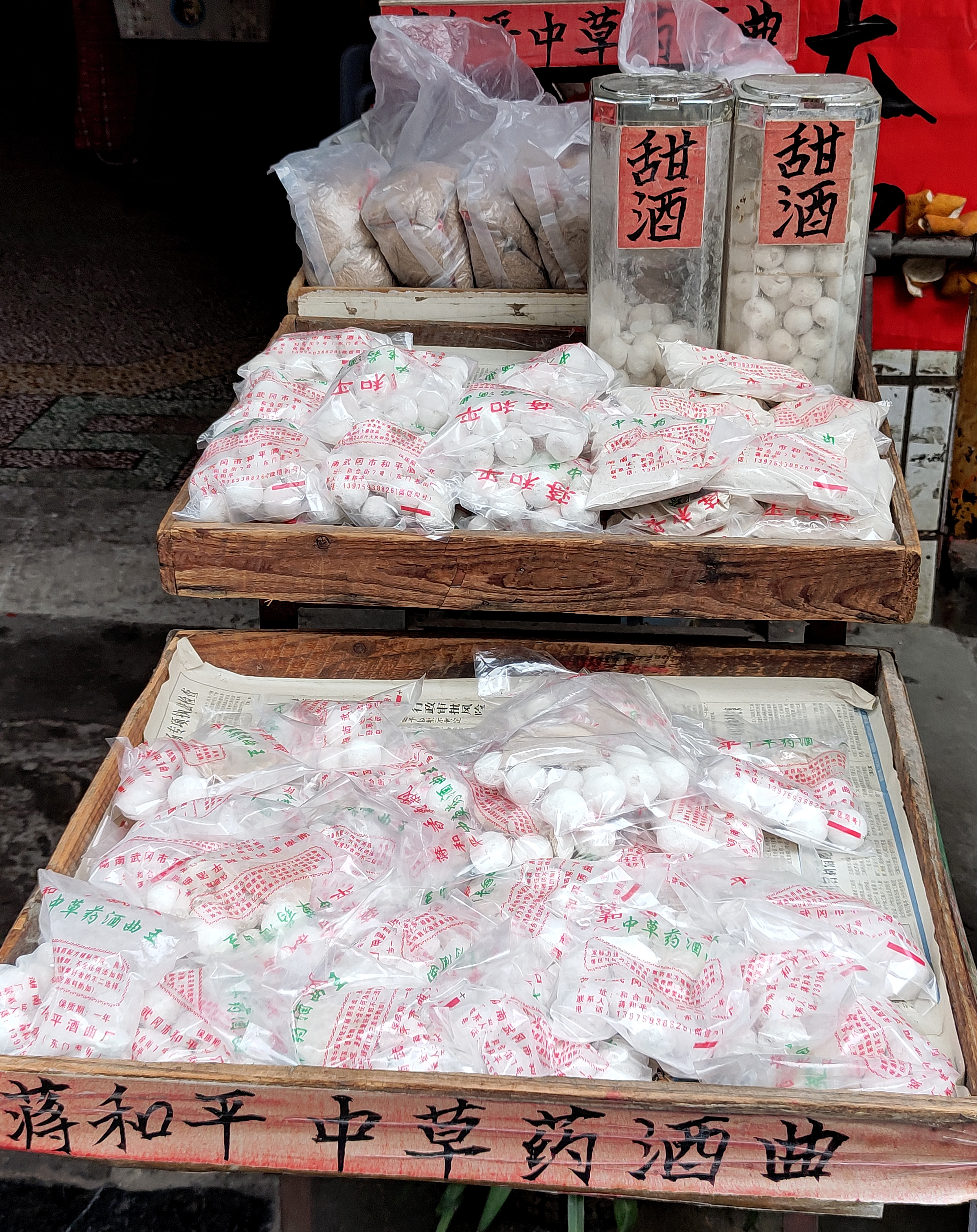 甜酒和酒曲。早上拍到了完整的甜酒（醪糟），中间有个坑，还没有下勺子的，买甜酒的人