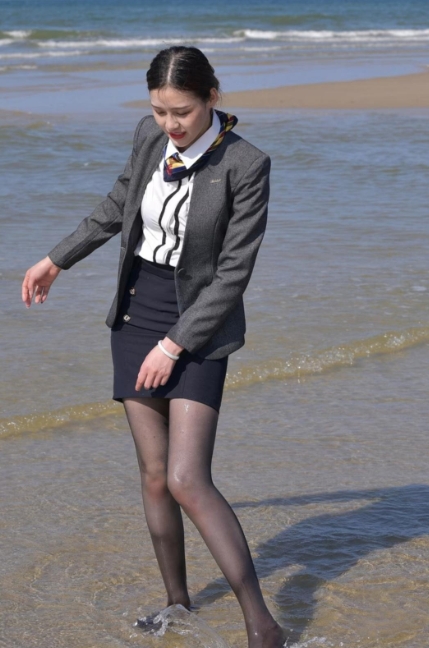 美女穿着干练的职业套装，深灰西装搭配白色衬衫，领口系着色彩斑斓的丝巾增添亮点。下