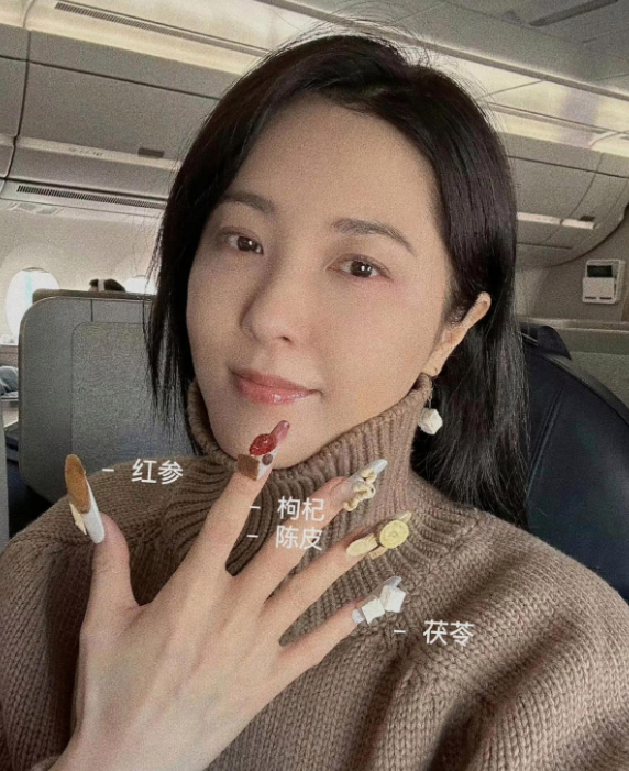 曾黎飞机上做了个中药美甲。
创意真不错！

在高空翱翔的航班上，曾黎选择了一种别