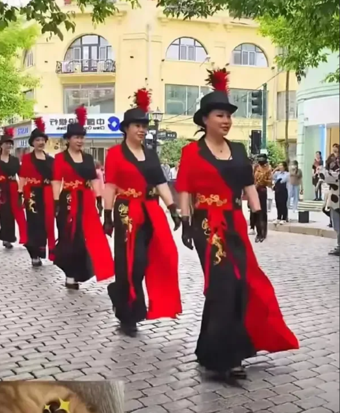 小区楼下经常聚集一些大妈，穿各种各样的衣服集合，然后一起出去。一边走一边喊口号。