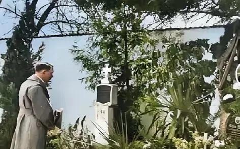 这张照片拍摄于1938年3月13日，希特勒吞并奥地利后回到了家乡，来到母亲坟前，