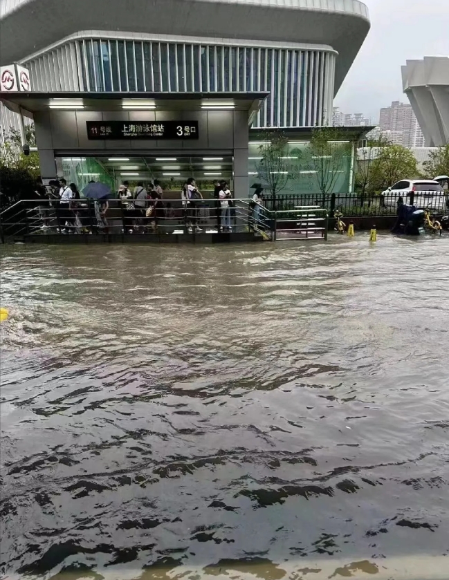 今早上海台风来袭暴雨啊！送娃上学太可怕，小区里积水过脚脖子，出小区别说车出不去，