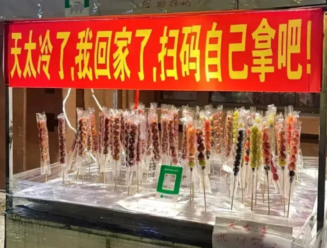 尔滨街上卖糖葫芦的车主打了横幅：天太冷，回家了，扫码自己拿吧。卖家放心把自己的糖