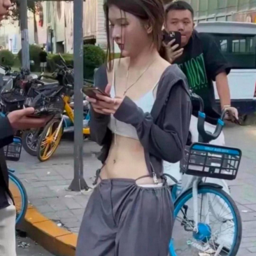    归家途中，在超市旁边瞧见一个女孩，身着这般的裤子在街边徘徊。其身后有一男子