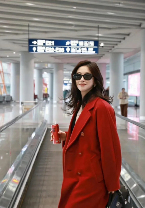 朱珠机场生图，一身红衣明艳大气，又美又飒，笑起来一对儿小梨涡温柔甜美，妥妥港风大