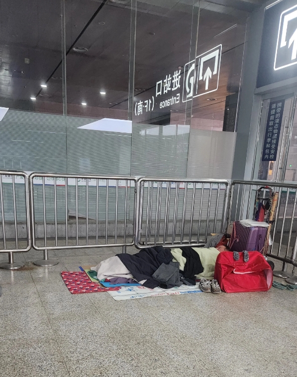 这是昨晚南京火车站外的情形，夜里11点半，农民工打着地铺在站外等火车，里面的雷锋