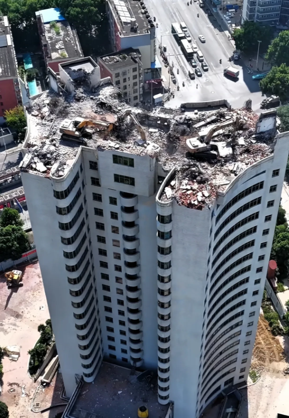 这几天，河南郑州热电厂20层高的办公大楼正在加急拆除中，多台大型挖掘机被吊上楼顶