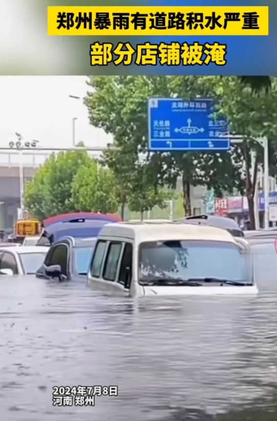 郑州市暴雨持续，航海路与紫荆山路交叉口积水很深，行人步履维艰，积水已没过膝盖。现