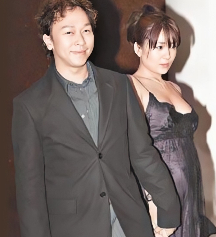 2006年，黄家强和日本妻子共同出席某活动的合影。镜头下的黄家强身穿西装，烫着时