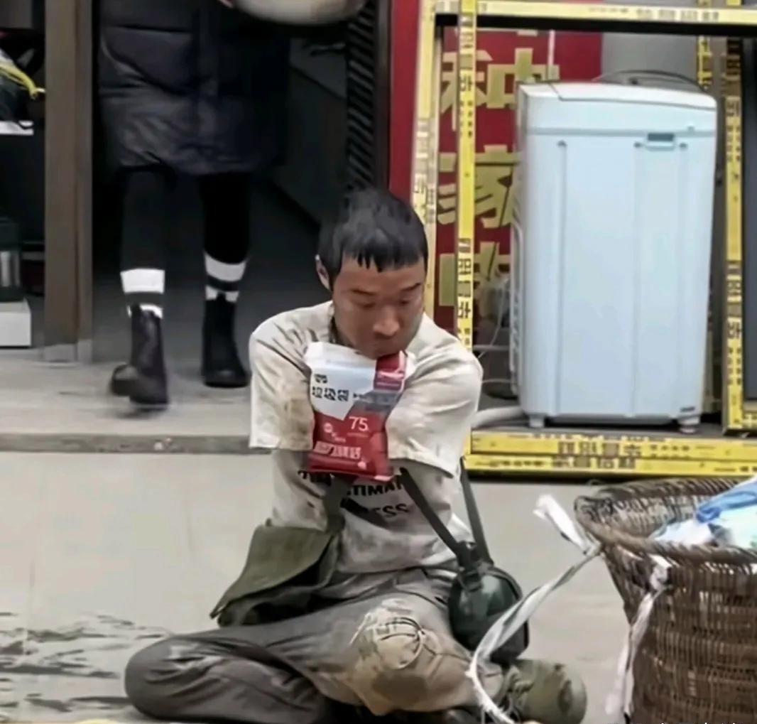 一位无臂小伙在路边摆摊卖垃圾袋，被身后店铺的一位女士泼了一盆水，全身被打湿，他转