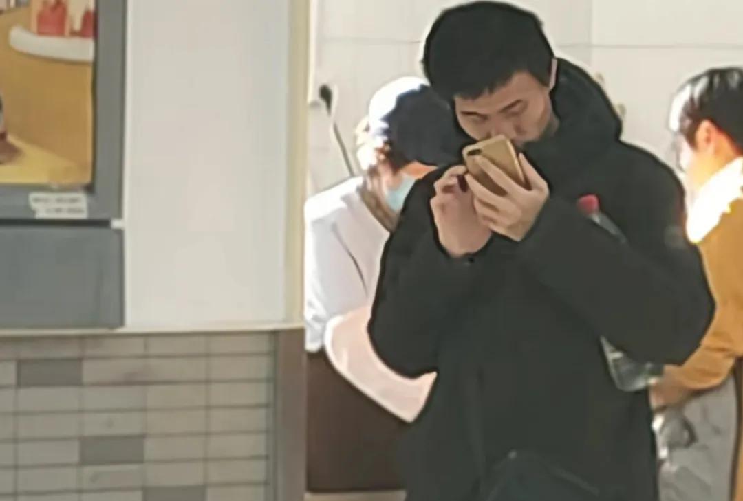 韦东奕静静地站在那里，来去匆匆走过的人和他成为鲜明的对比。有人说他是不是在给女朋