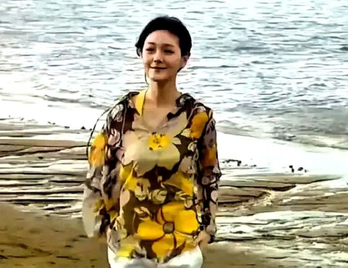 这张照片是大S跟秦汉，当时的她应该是在拍摄电视剧。

她身穿一件黄色大妈的花衫，