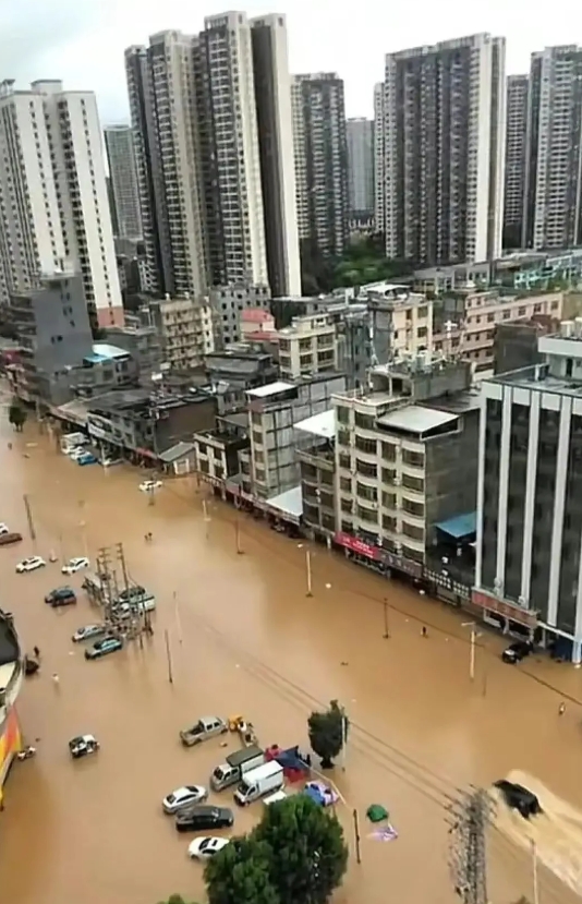 广东的暴雨若继续肆虐，后果不堪设想。江畔的高楼已被洪水淹没至一层，街道的护栏已难