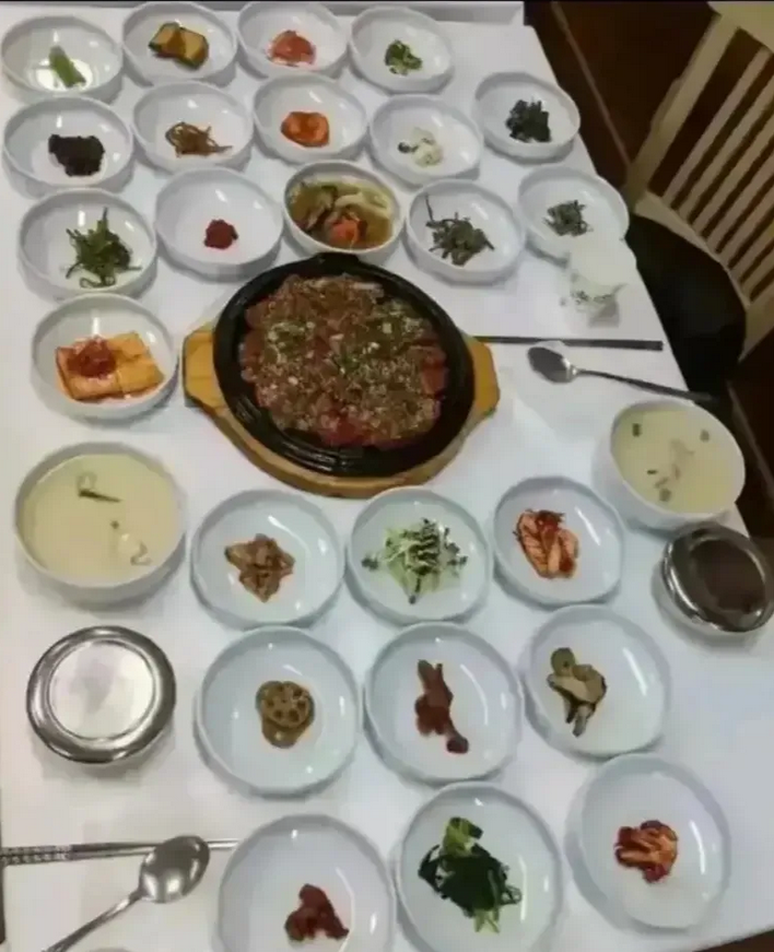 这是韩国2个人的晚餐，摆了满满一桌，28碟菜！两个人吃饭，用了32个餐具，27碟