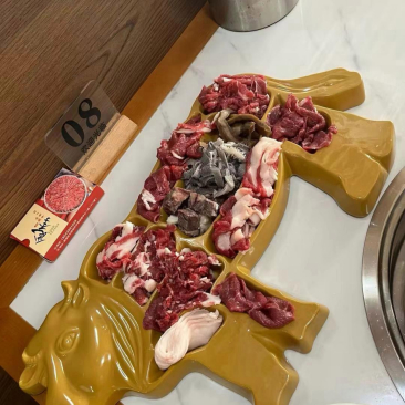    陪朋友去餐厅享用牛肉火锅，服务员端上来一只呈牛形状的盘子，里面一格格装着不