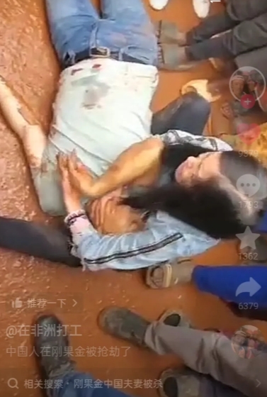 中国夫妇在刚果金被抢劫，男人身上多一个伤口，躺在地上不省人事，妻子紧紧的抱住昏迷