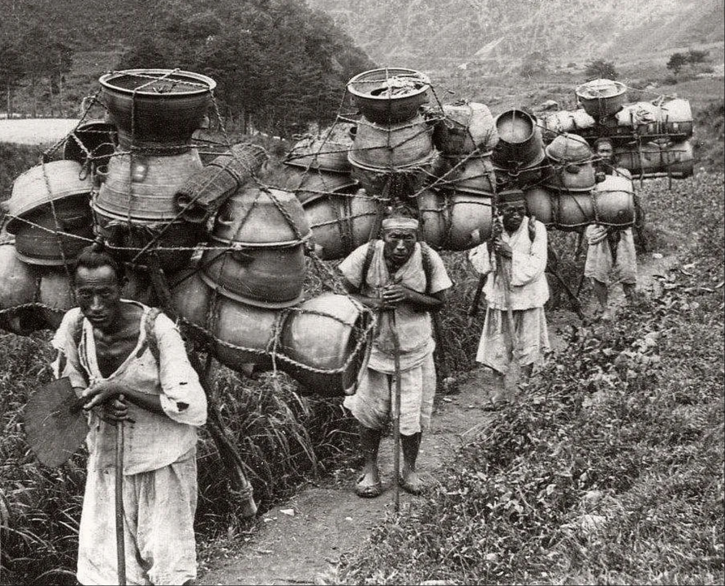 扛着锅的男人。韩国，约 1900 年。